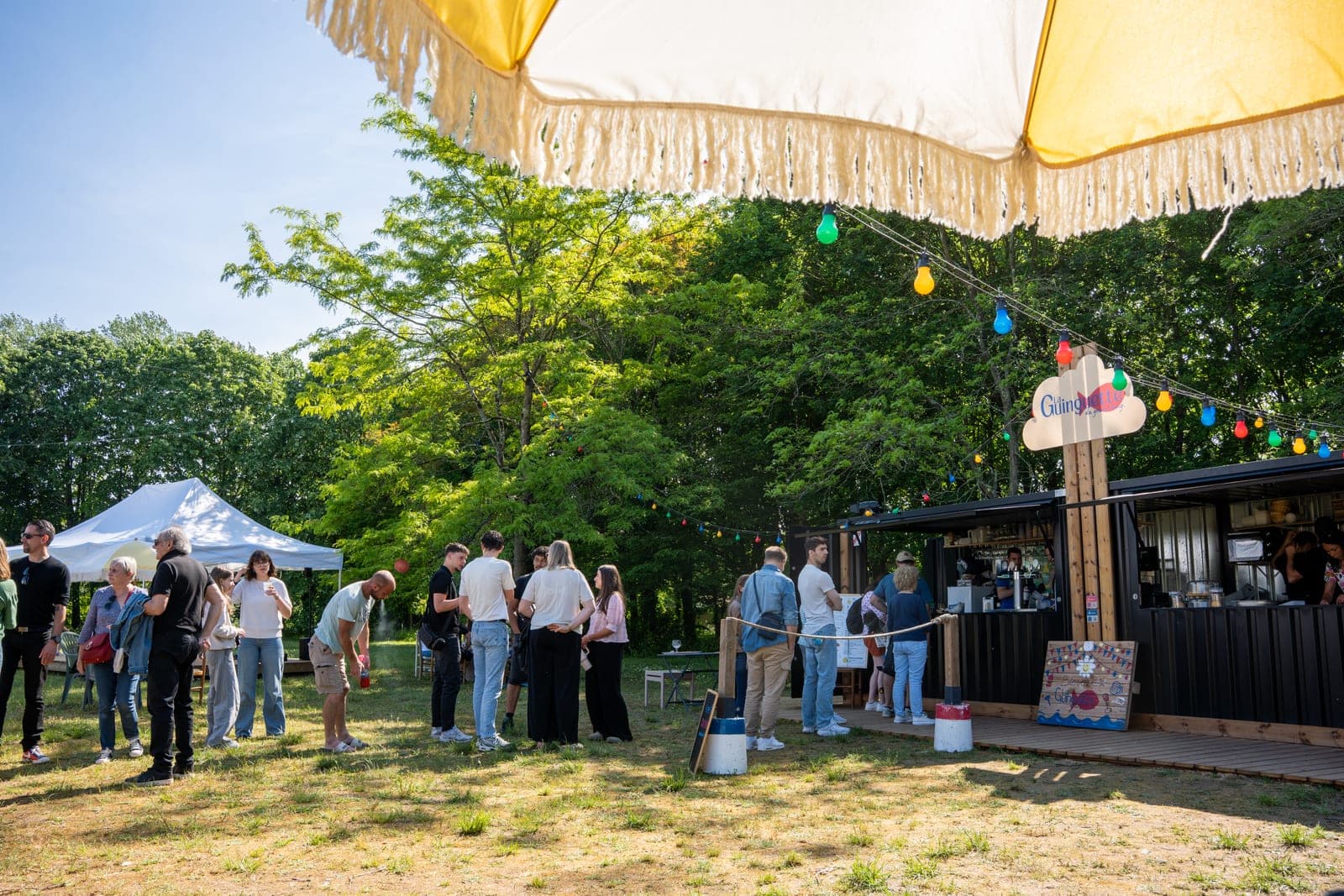 Guirlandes et file d'attente devant le bar container